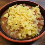 Bowl of pintos with shredded cheddar cheese